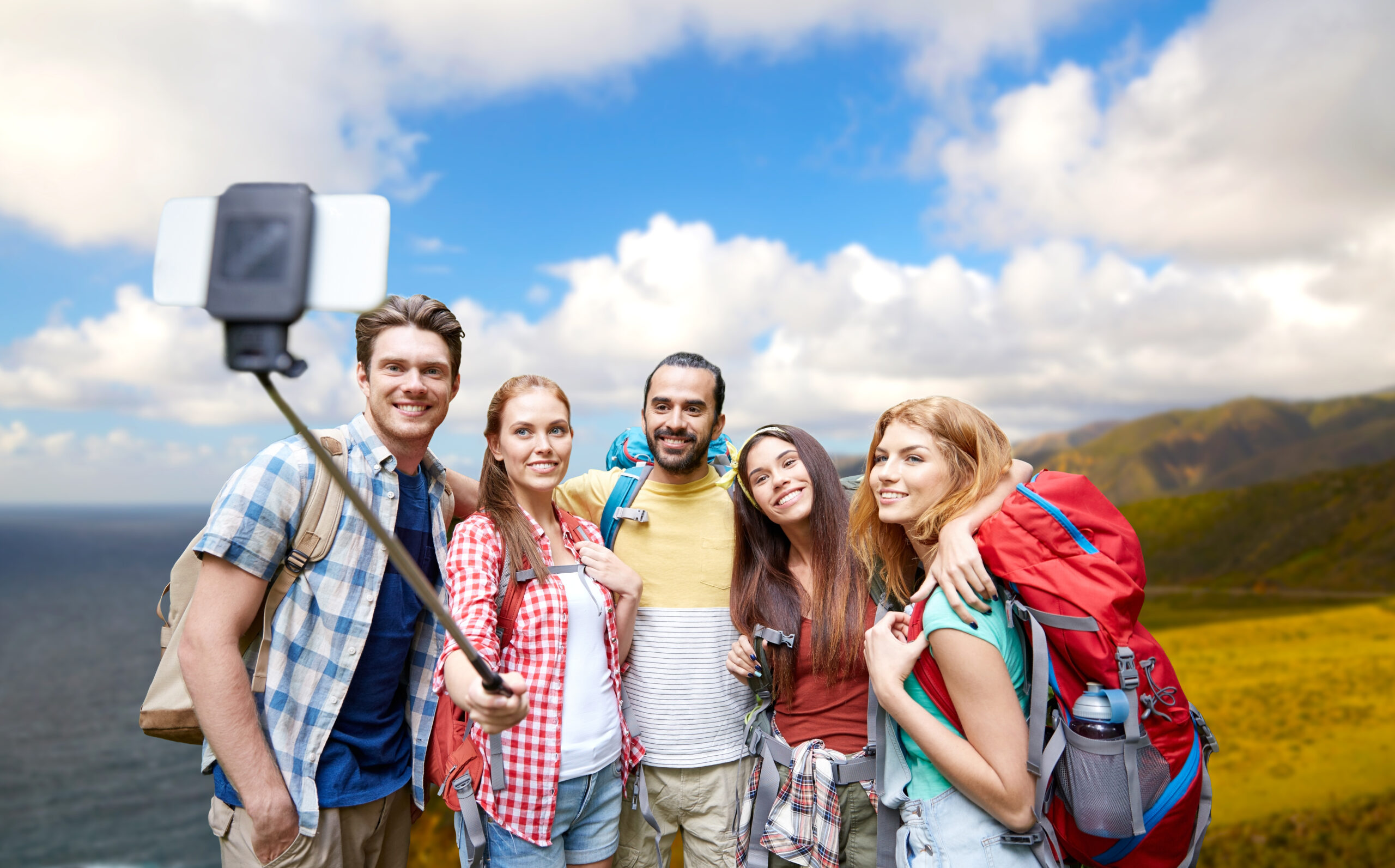 Happy travellers with backpacks taking a selfie, ready to explore the UK