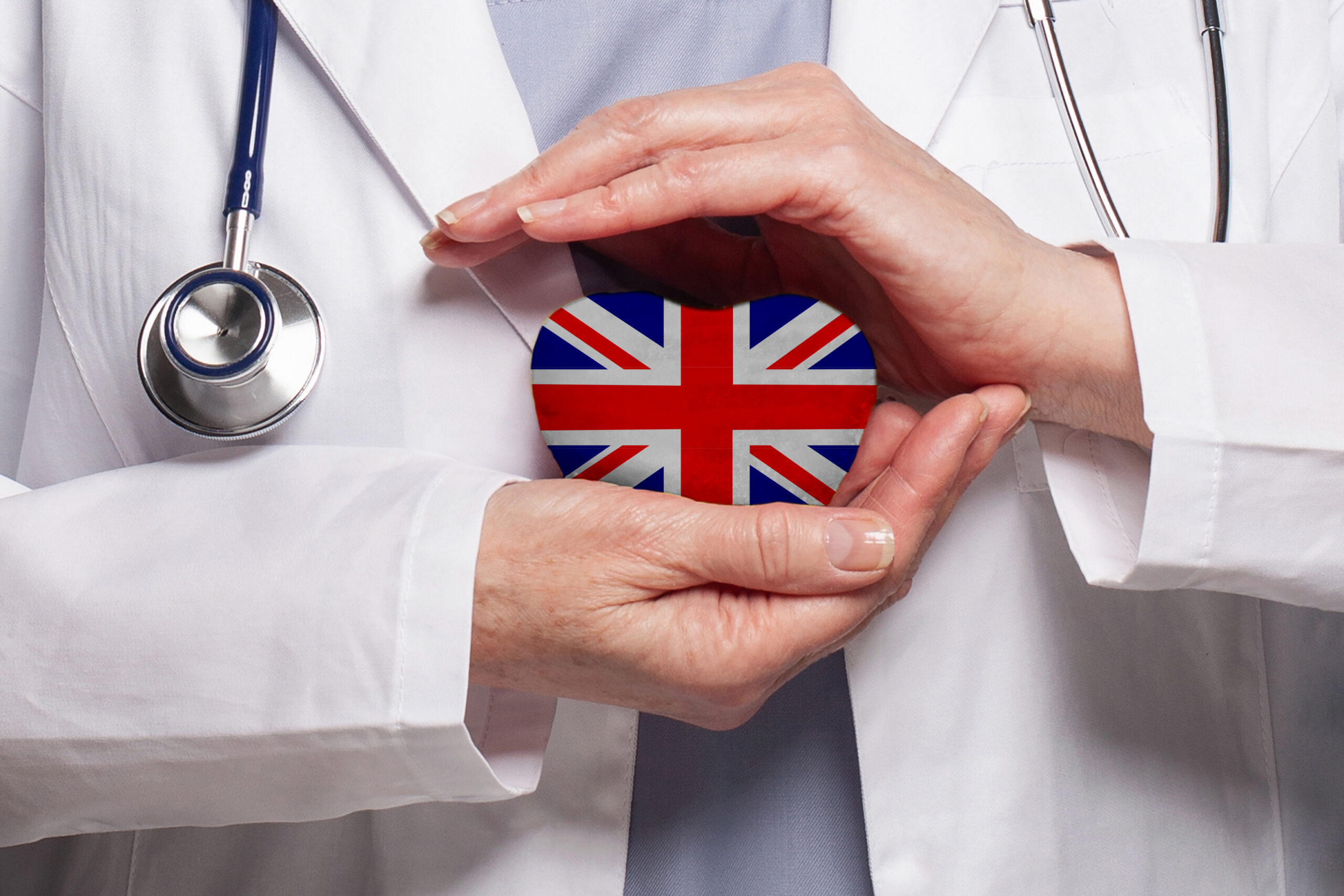 UK doctor holding a heart with the United Kingdom flag  medical treatment concept