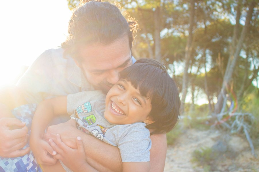 A father hugging his young daughter in warm sunlight
