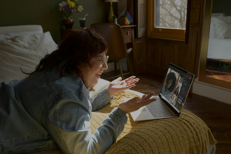 A woman waving to her family on a laptop video call