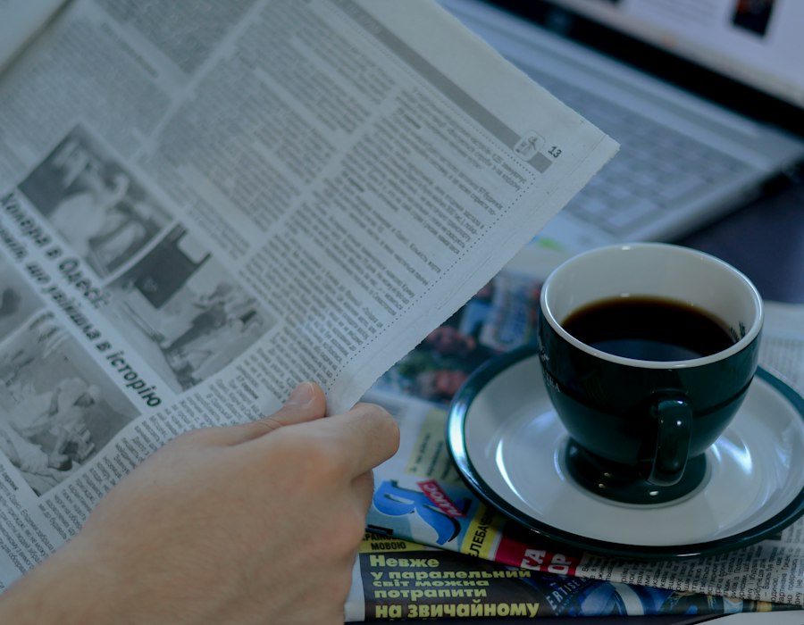 A morning coffee beside a folded newspaper