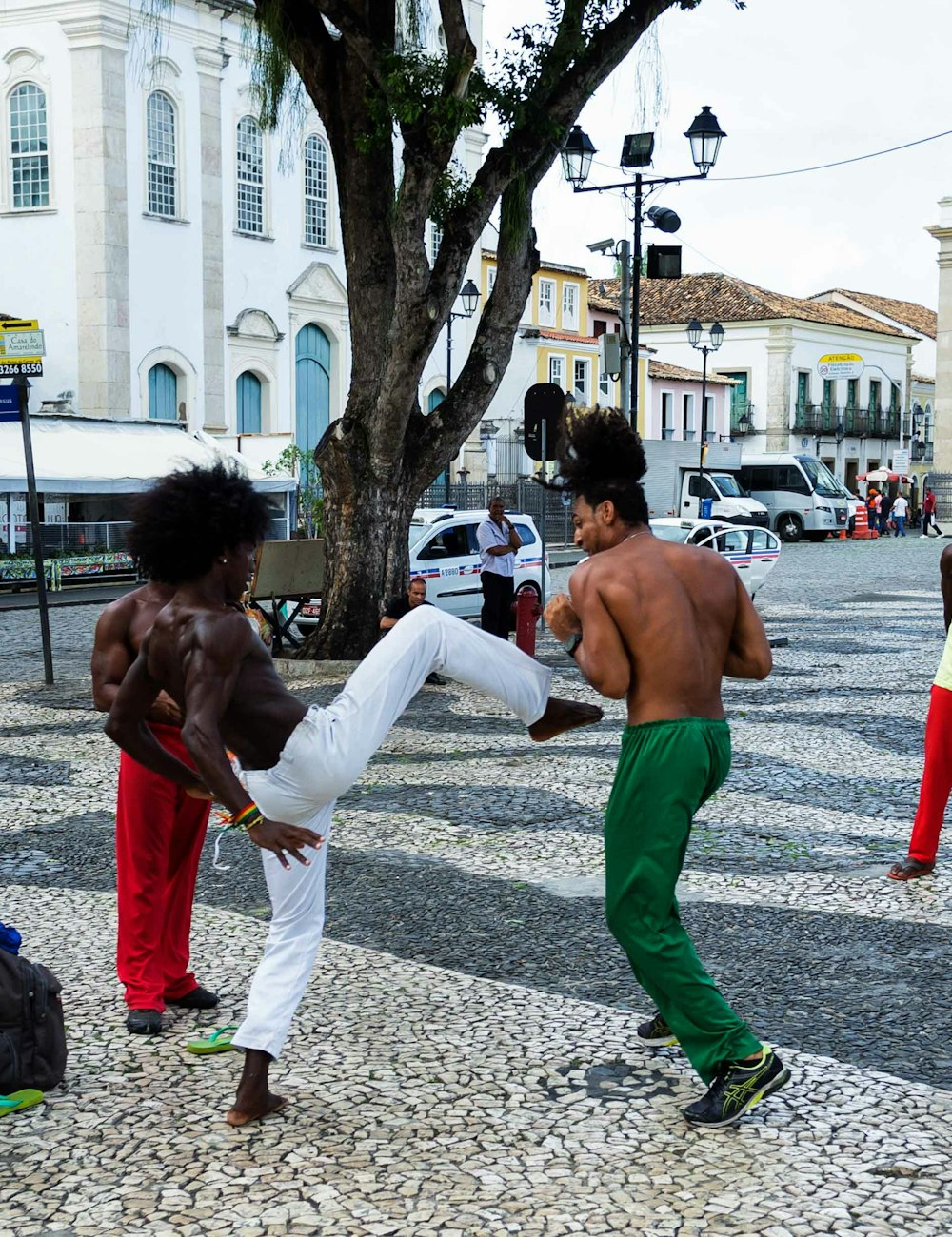 Young people dancing capoeira in a colourful square in Salvador