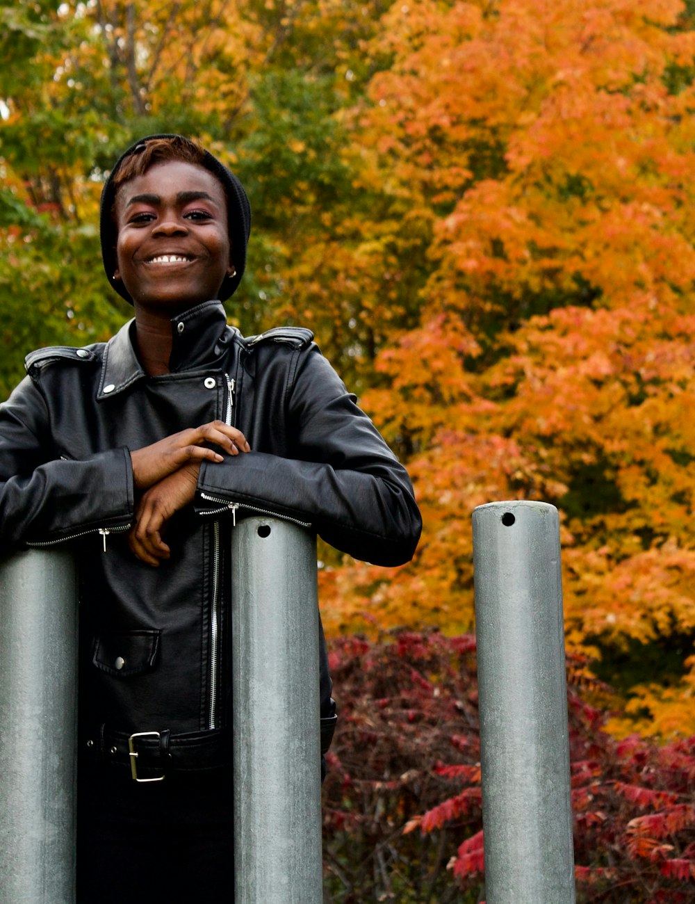 A smiling student among orange autumn maple leaves in Canada