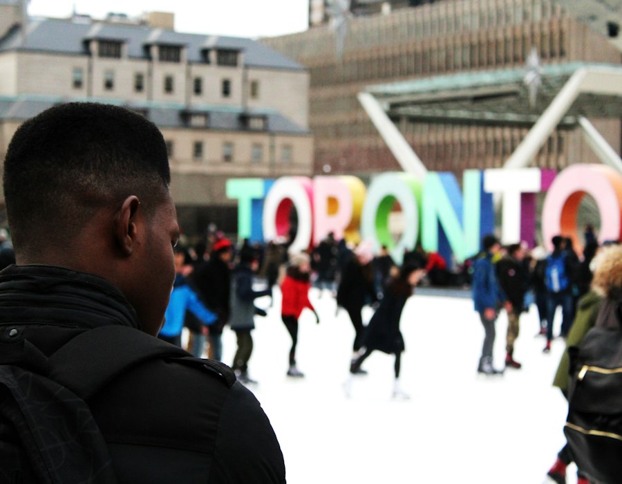 Friends ice skating at Nathan Phillips Square in Toronto