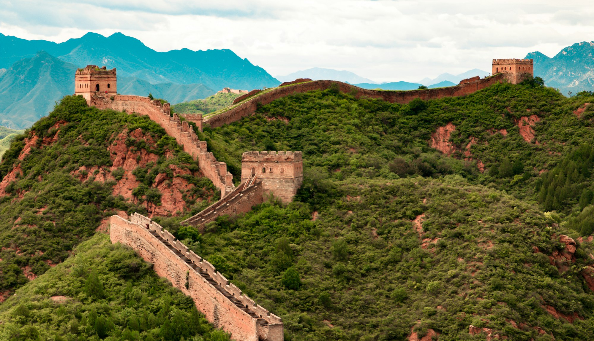 The Great Wall of China running across green mountain ridges