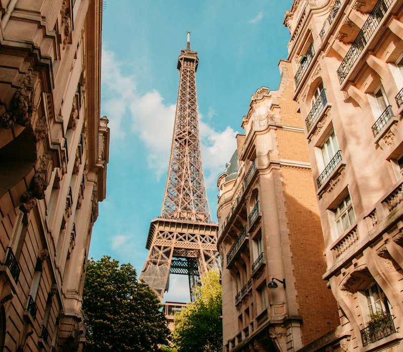 A Paris street with the Eiffel Tower between the buildings
