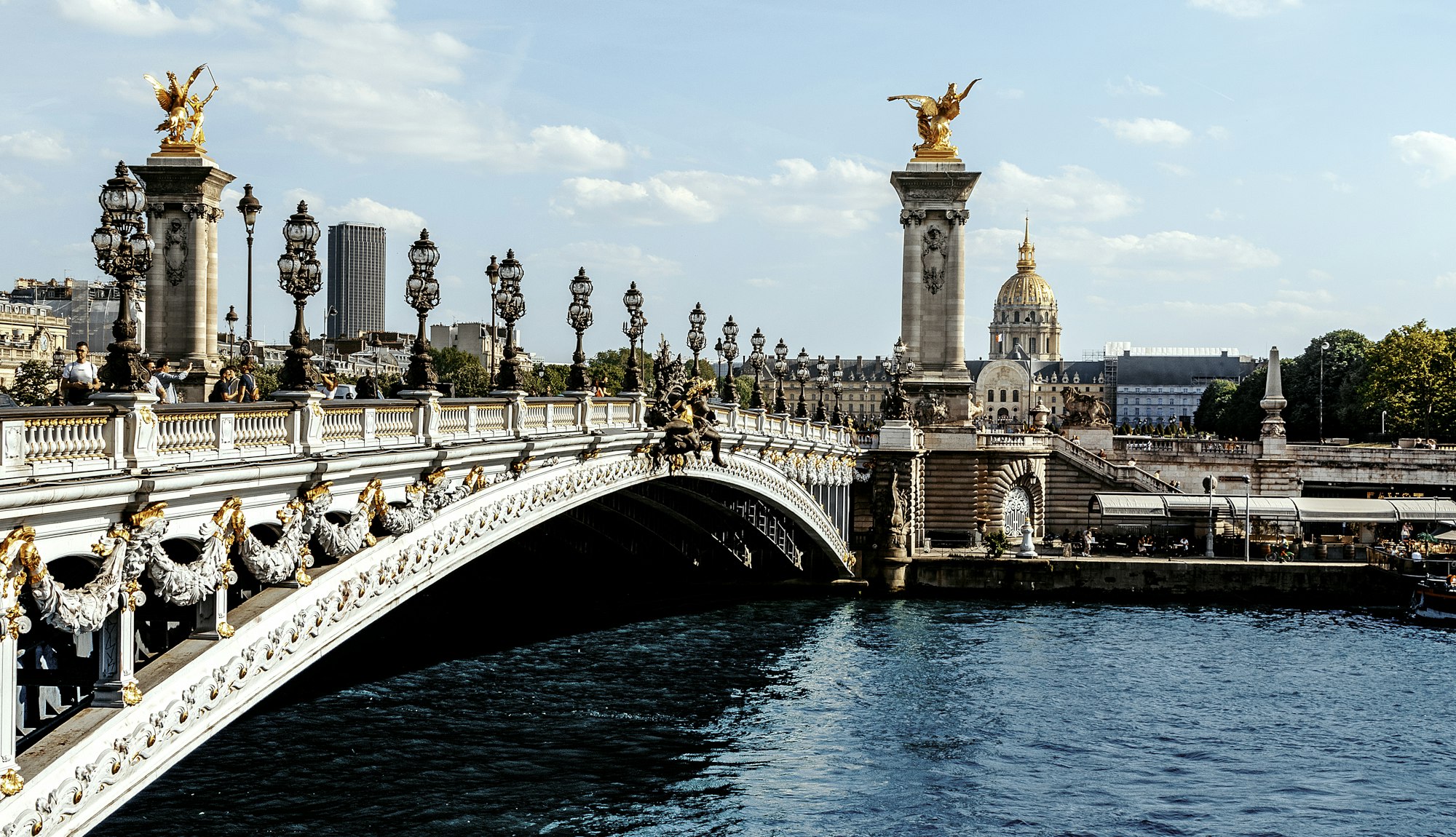 The golden statues of Pont Alexandre III over the Seine in Paris on a sunny day