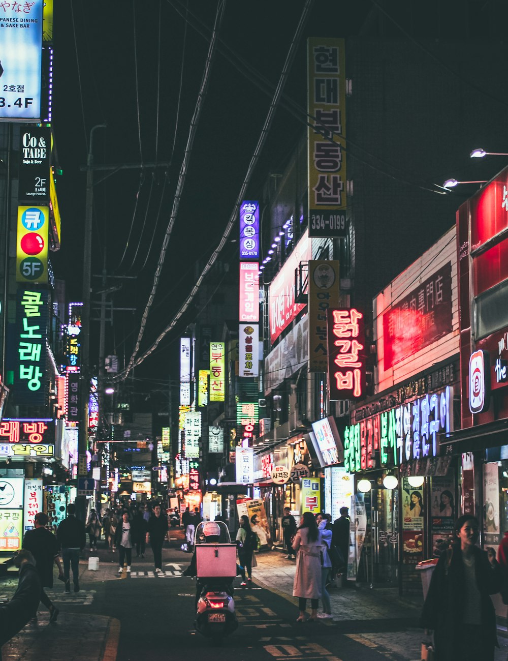Neon signs over a busy shopping street in Seoul at night