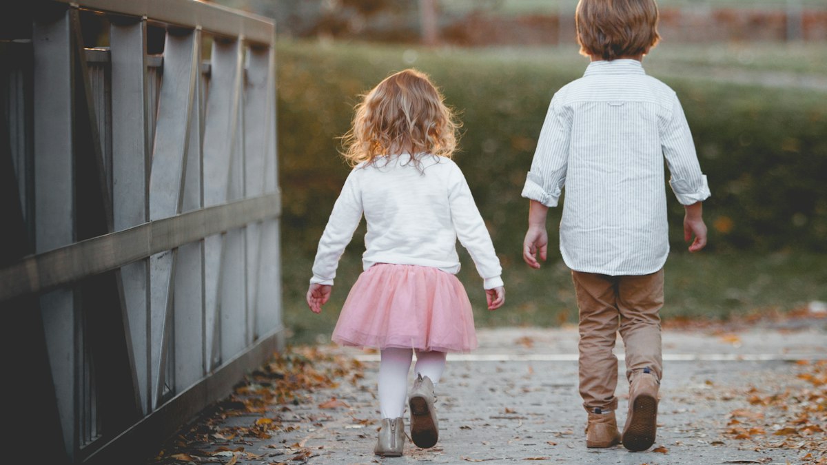Two young siblings walking together