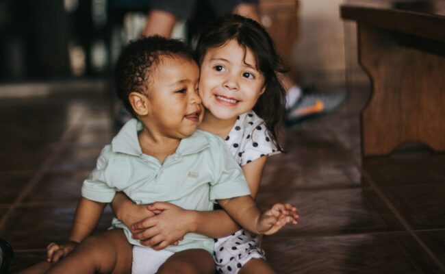 Siblings hugging and laughing