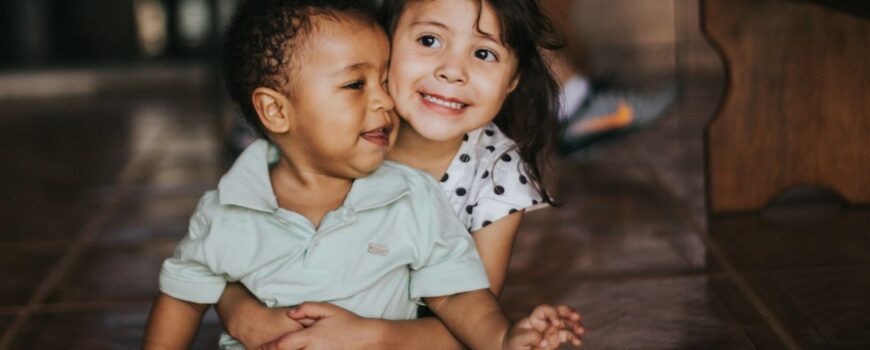Siblings hugging and laughing