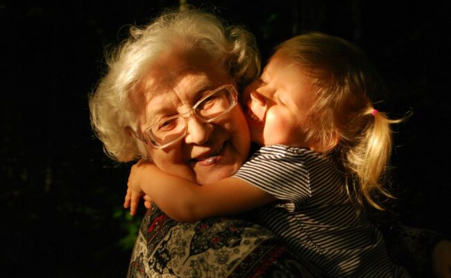 A grandmother hugging her grandchild