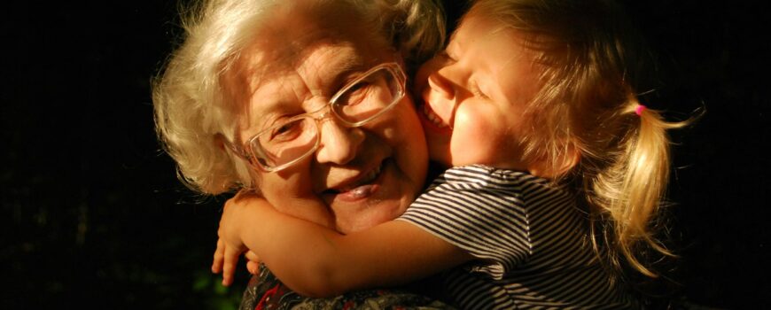 A grandmother hugging her grandchild