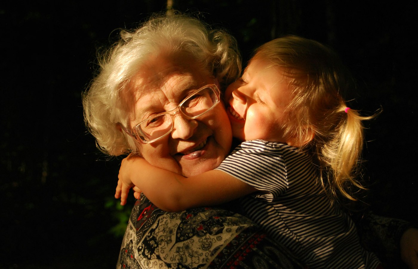 A grandmother hugging her grandchild