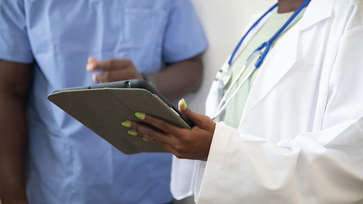A doctor reviewing records on a tablet