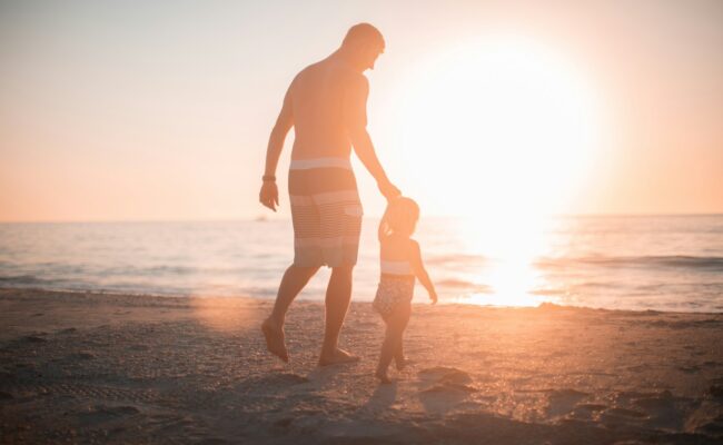 A parent and child walking at sunset