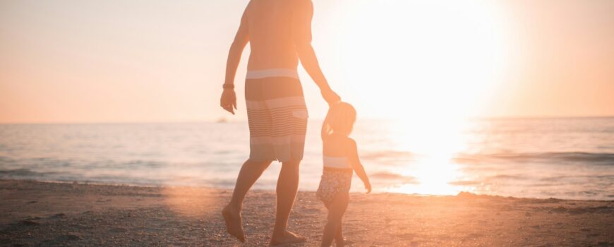 A parent and child walking at sunset