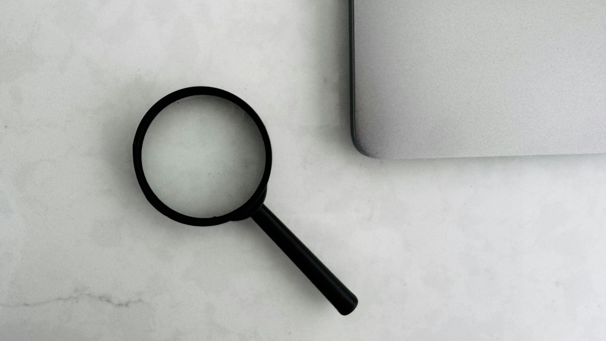 A magnifying glass on a white desk