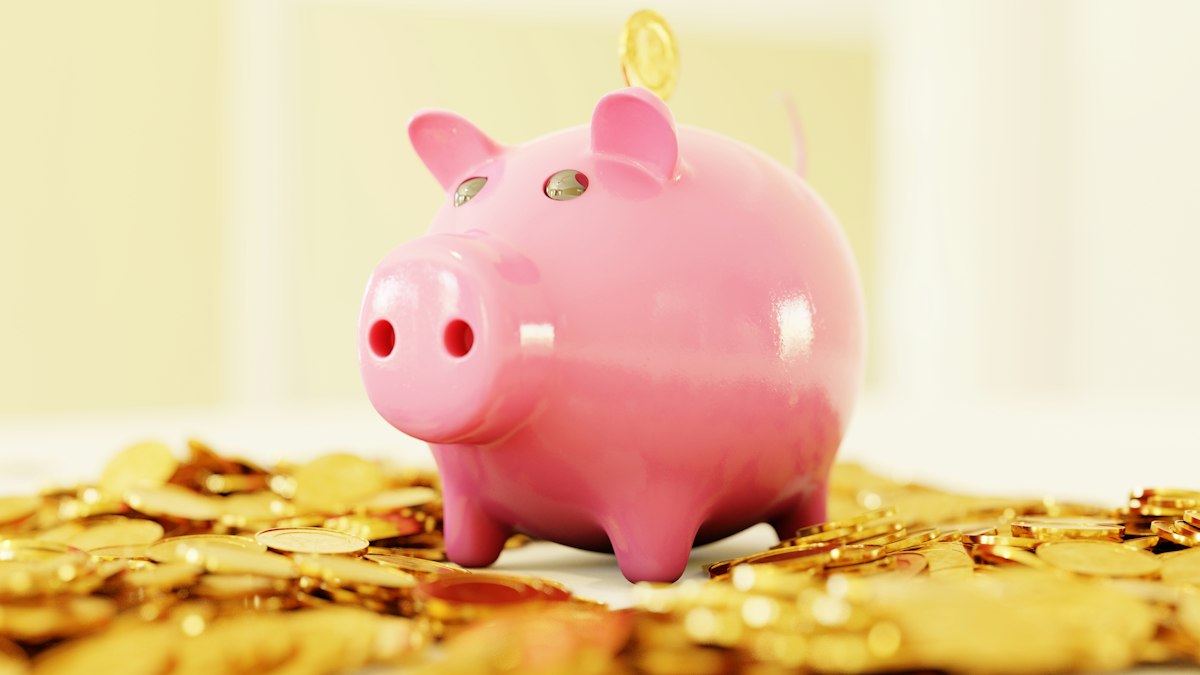 A pink piggy bank on coins