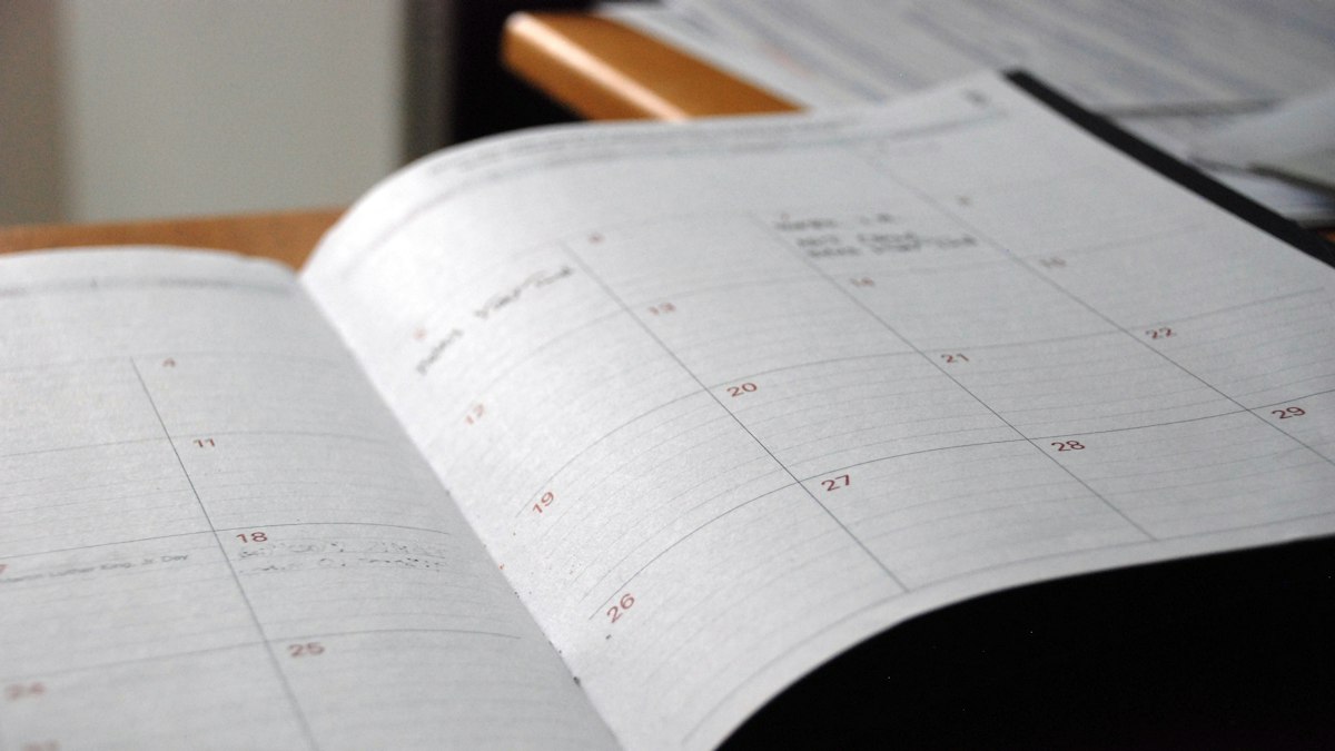 An open monthly planner on a wooden desk