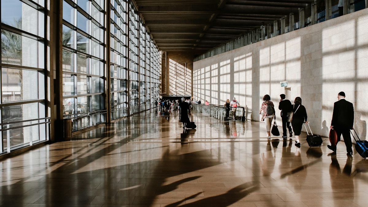 Travellers walking through a bright airport