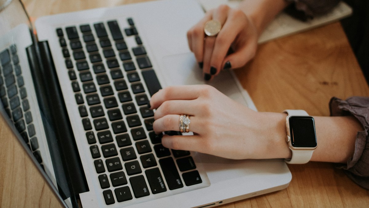 Hands typing on a laptop