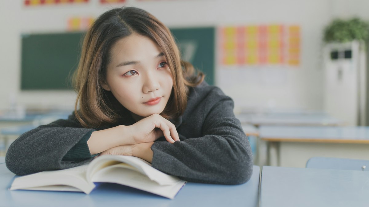 A student thinking over a notebook