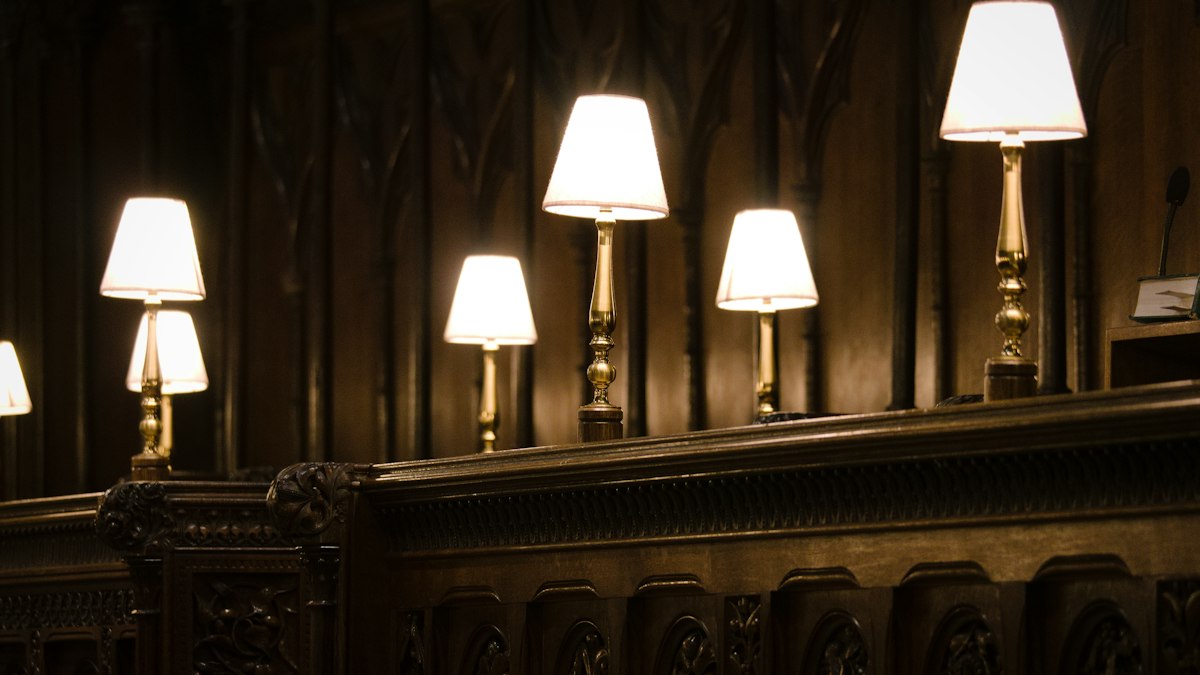 A quiet library desk with a lamp
