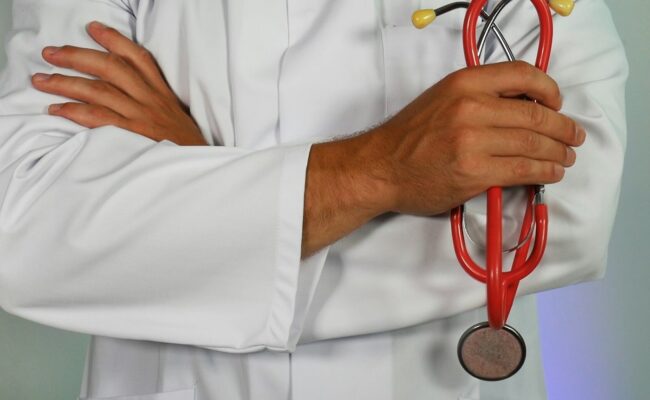 A doctor in a white coat holding a stethoscope