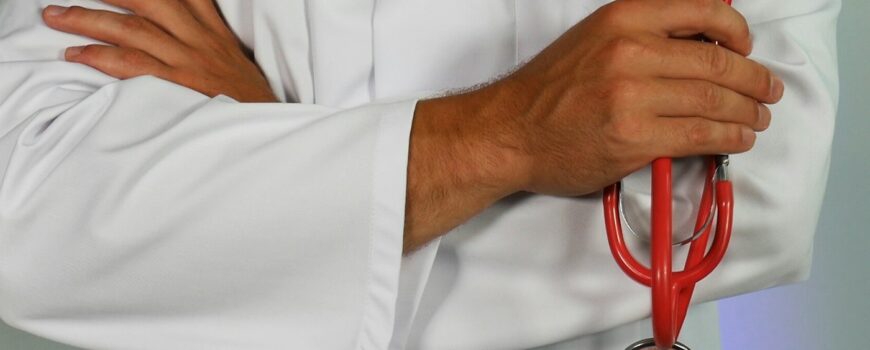 A doctor in a white coat holding a stethoscope