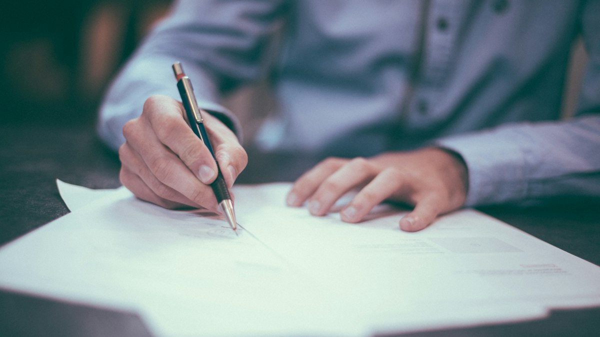 Signing official documents at a desk