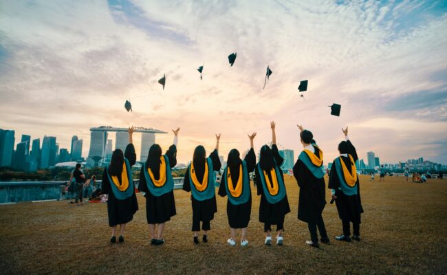 Graduates in gowns celebrating outdoors