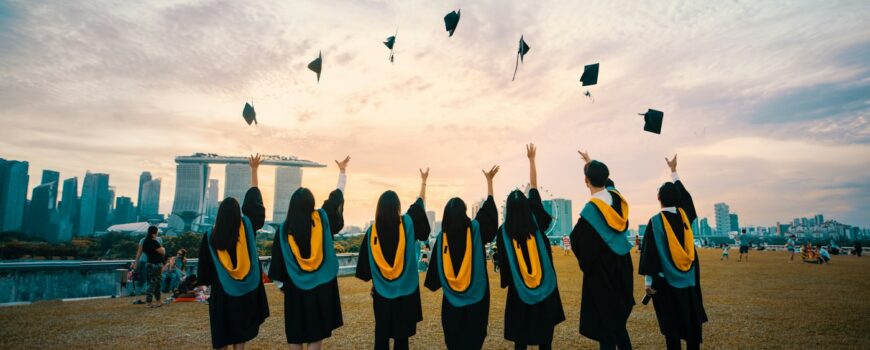 Graduates in gowns celebrating outdoors