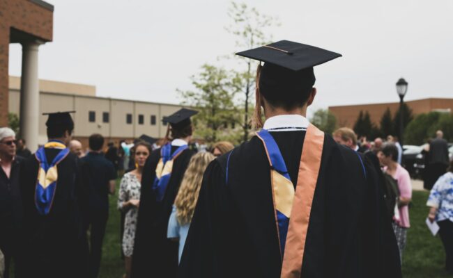 A graduate in an academic gown and cap at a UK graduation