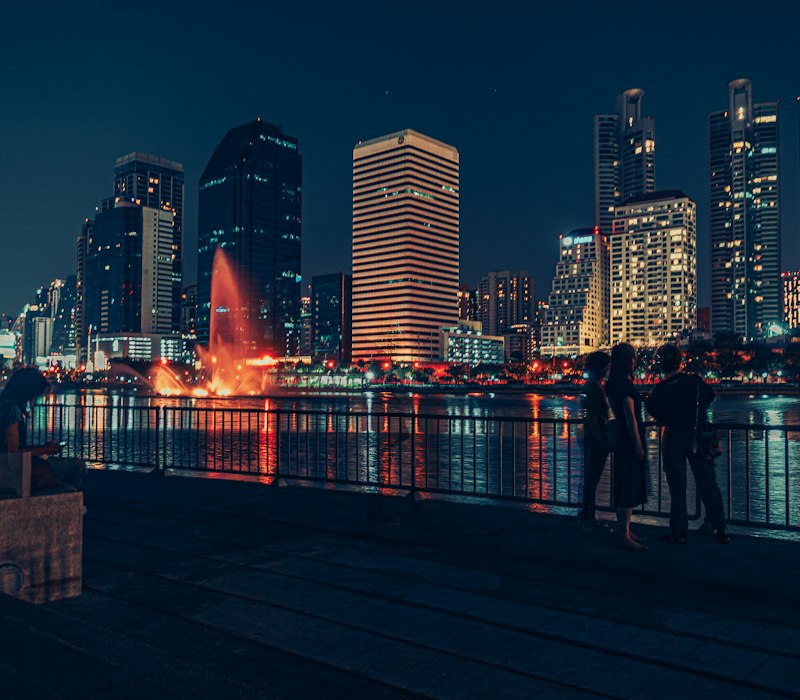 The Bangkok skyline lit up at night over the river