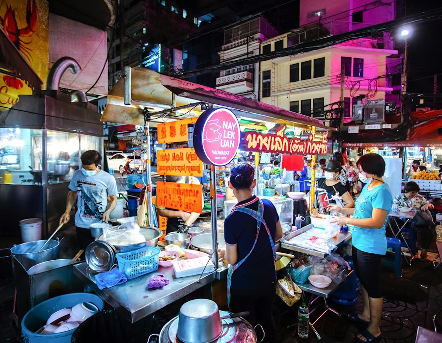 A busy Thai street food lane in the evening