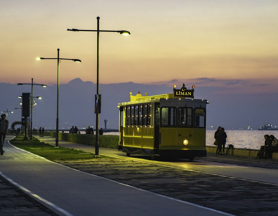 A yellow tram on the seafront in Izmir at sunset