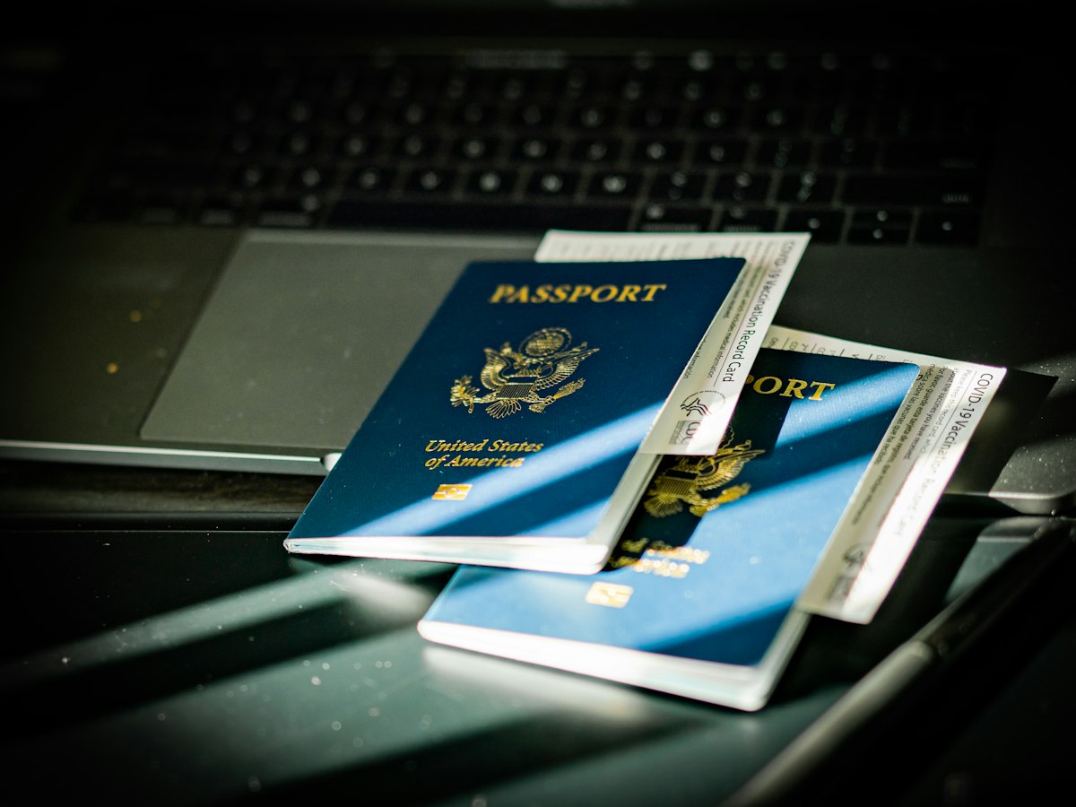 A passport resting on a laptop keyboard, the point where an online UK visa application is submitted