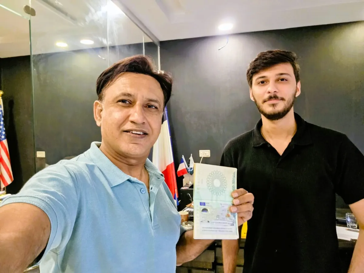 Mujtaba Maharvi with a student holding his approved visa at the Westside office