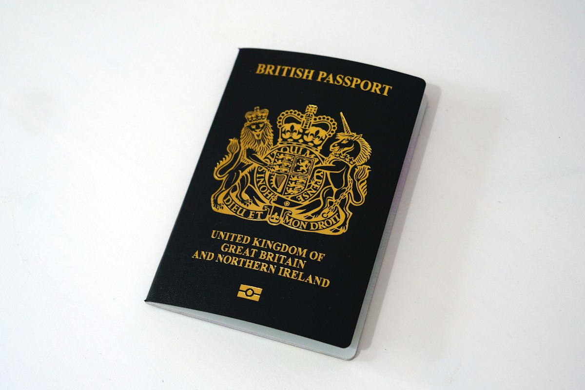 A British passport on a table; every UK application now links to one person record in Atlas