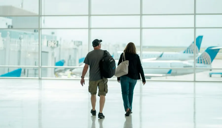 A couple walking through an airport with their bags